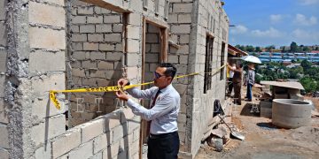 Kasi Ops Satpol PP Kota Tanjungpinang, Dian Asmara Siregar pada saat memasang PPNS LINE di Perumahan Subsidi yang tidak memiliki IMB. Foto : Detak.Media