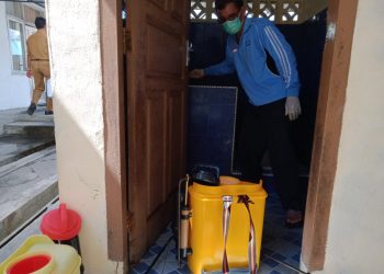 Salah seorang petugas sedang menyiapkan cairan disenfektan.