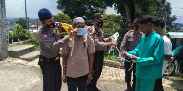 Personil Polsek Batu Ampar pada saat memasangkan masker kepada salah seorang jamaah, f : ist