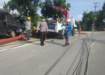 Petugas saat memperbaiki tiang listrik yang ditabrak pikap, f : ist