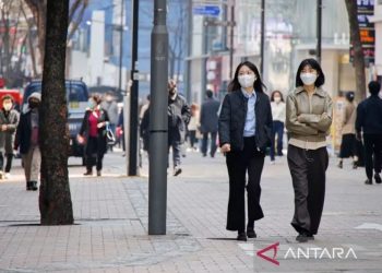 Arsip - Warga sambil memakai masker berjalan di distrik perbelanjaan di tengah pandemi COVID-19 di Seoul, Korea Selatan, 16 Maret 2022. ANTARA/REUTERS/Heo Ran/as