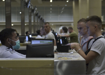 (Foto: Antara/Fikri Yusuf) Petugas imigrasi melakukan pemeriksaan keimigrasian terhadap warga negara asing (WNA) yang baru tiba di Bandara Internasional I Gusti Ngurah Rai, Bali, Rabu (5/2/2020).