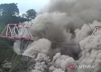 Luncuran Awan Panas Guguran (APG) Gunungapi Semeru menerjang Jembatan Gladak Perak di Lumajang, Jawa Timur, Minggu (4/12/2022). Pusat Vulkanologi dan Mitigasi Bencana Geologi (PVMBG) menaikkan status Gunungapi Semeru dari Siaga menjadi Awas atau dari Level III menjadi Level IV. ANTARA FOTO/Dok BNPB/Zk/YU/pri. (ANTARA FOTO/ZABUR_KARURU)