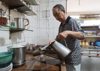 Pemilik Kedai Kopi Damai Baru, Acong (72) saat Menuangkan Kopi Dari Teko ke Cangkir Berbahan Keramik, foto: Mael/detak.media