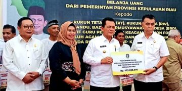 Gubernur Kepri Ansar Ahmad (kiri) menyerahkan bantuan secara simbolis yang diterima langsung oleh Bupati Natuna Wan Siswandi