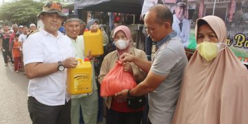 Kasi Pengendalian Kebutuhan Pokok dan Kebutuhan Penting Setia Kurniawan, SE bersama Camat Bintan Timur Sofyan, SE berfoto bersama warga, foto: Dewi Sarah/detak.media
