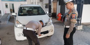 Kanit Regident, Ipda Alvin saat Memasang Plat Nomor Putih untuk Kendaraan Roda Empat, foto: Mael/Detak.media