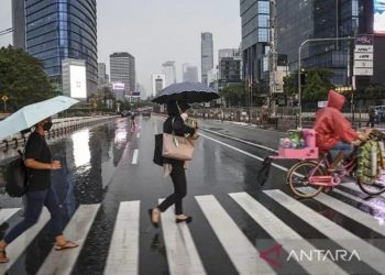 Arsip foto - Sejumlah warga menggunakan payung saat hujan di kawasan Jalan Jenderal Sudirman, Jakarta, Selasa (4/10/2022). ANTARA FOTO/M Risyal Hidayat/tom/pri.