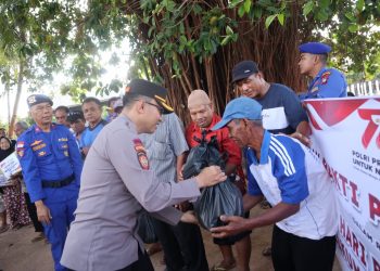 Kapolres Bintan, AKBP Riky Iswoyo saat membagikan sembako kepada Masyarakat Bintim, foto: ist