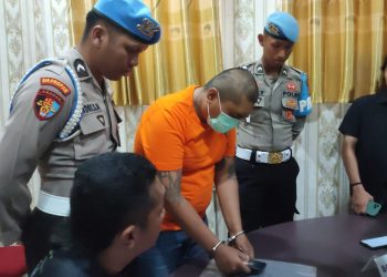 Pelaku WAS (32) saat memperagakan modus penipuannya menggunakan ponsel melalui aplikasi editor (foto : Zaki/DM)