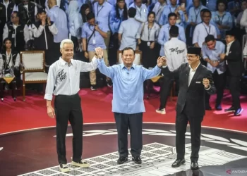 Capres nomor urut satu Anies Baswedan (kanan), Capres nomor urut dua Prabowo Subianto (tengah) dan Capres nomor urut tiga Ganjar Pranowo (kiri) berpegangan tangan usai beradu gagasan dalam debat perdana Capres dan Cawapres 2024 di Gedung KPU, Jakarta, Selasa (12/12/2023). ANTARA FOTO/Galih Pradipta/YU.